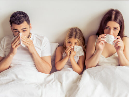 Family in bed with tissues, indoor allergies